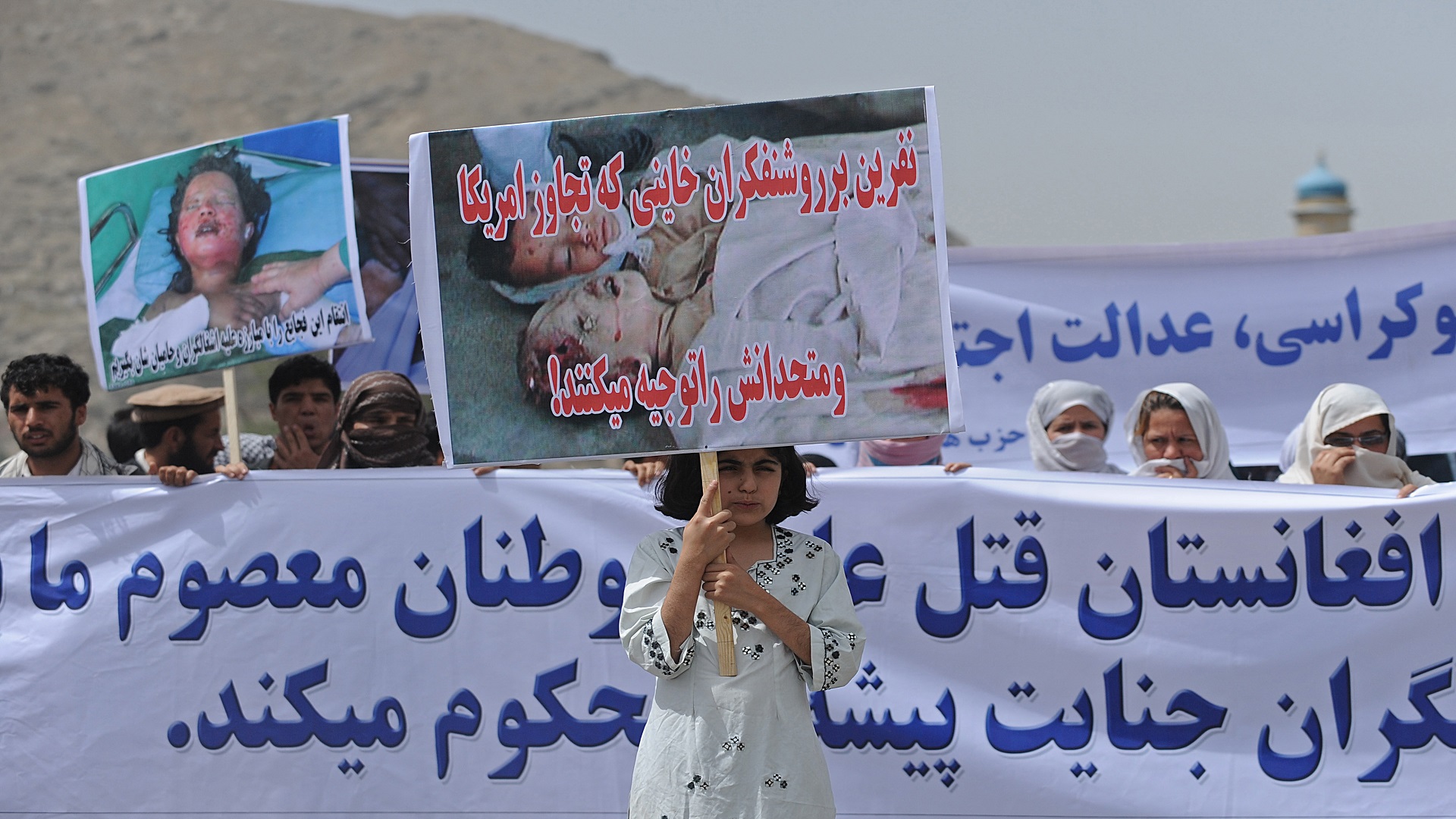 Afghan demonstrators hold placards and m جلنار Jollanar